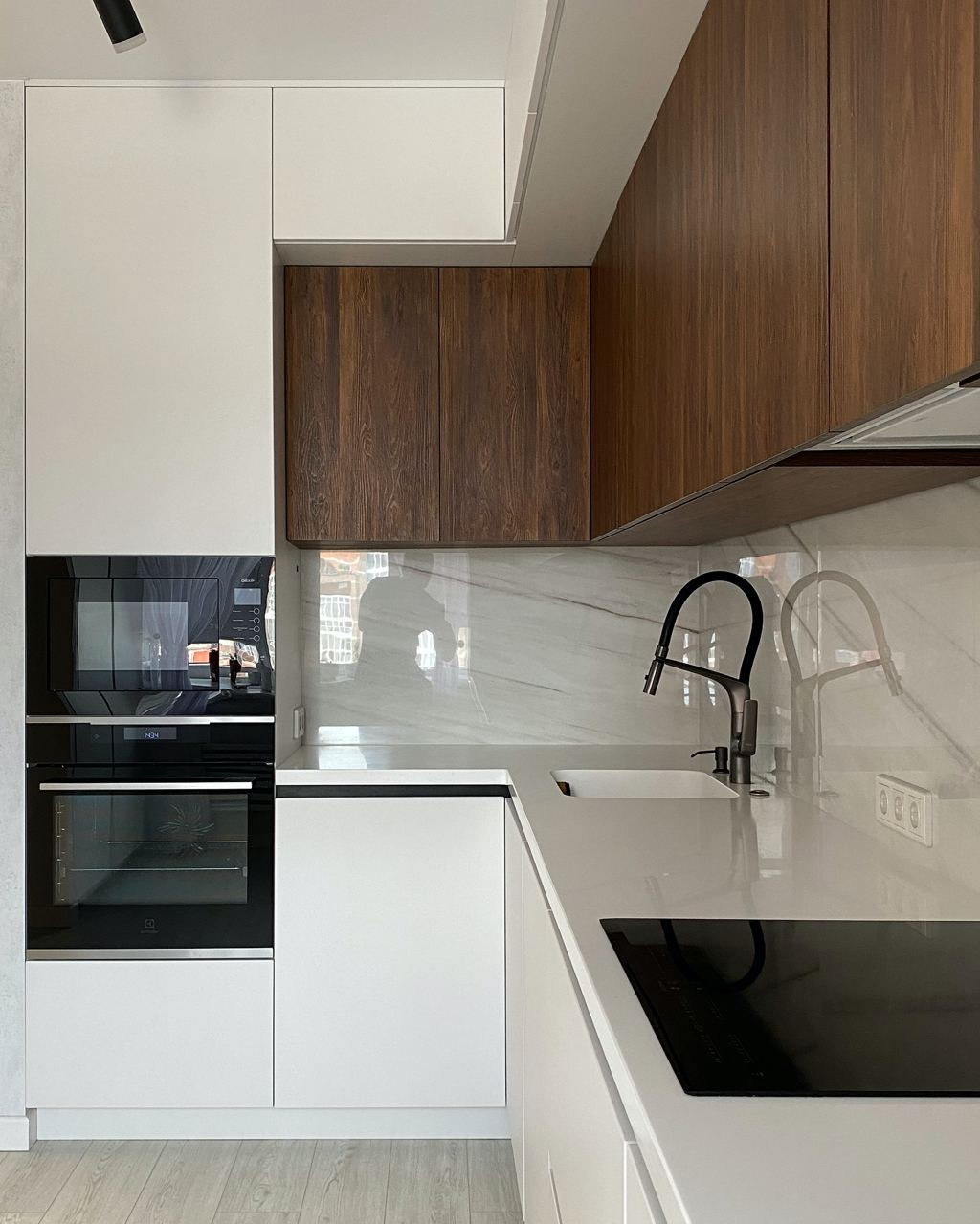 Светлая встроенная угловая кухня с однотонными матовыми фасадами