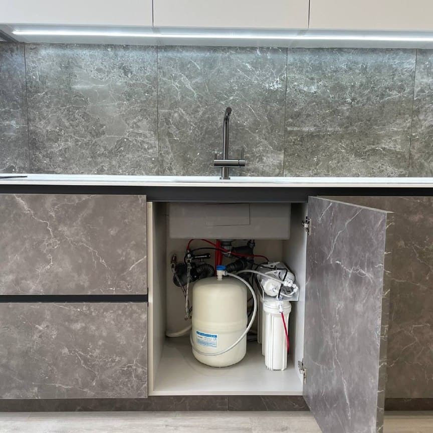 Широкая прямая кухня с высокими шкафами и фасадами под мрамор