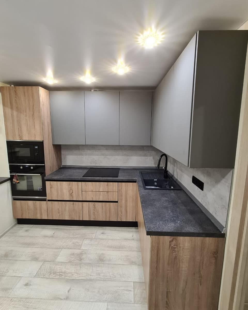 Стильная угловая кухня с деревянными и матовыми фасадами цвета графит