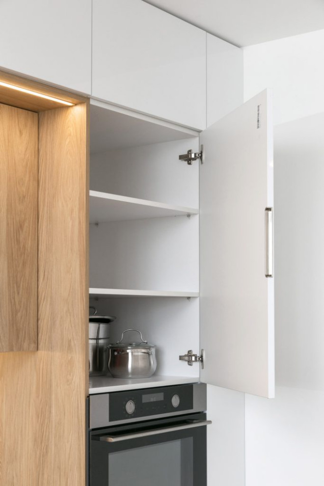 Белая глянцевая кухня с деревянными светлыми фасадами