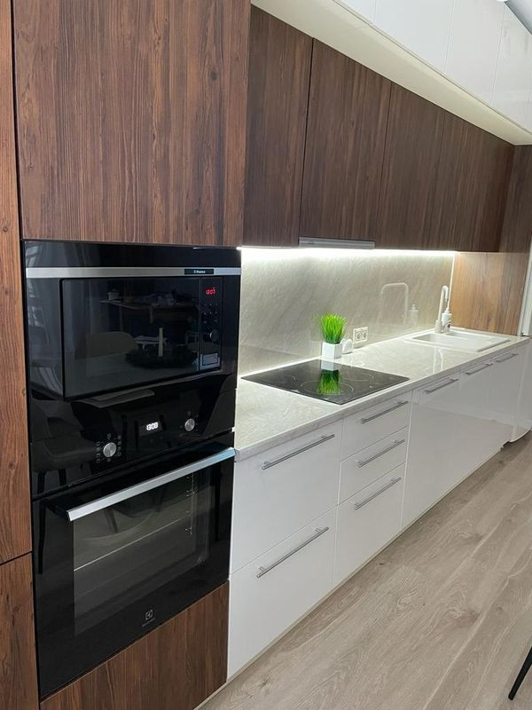 Прямая стильная кухня под потолок с глянцевыми и древесными фасадами