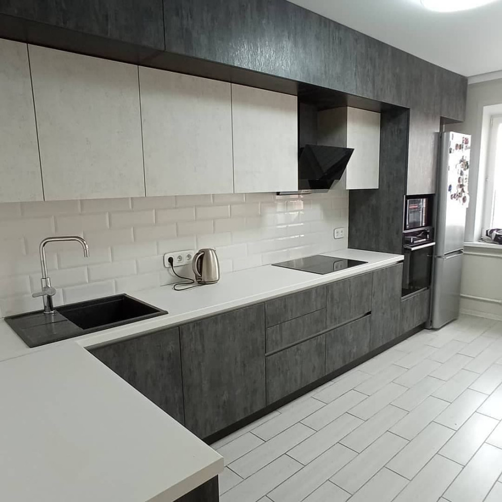 Широкая угловая черно-белая кухня с фасадами под камень