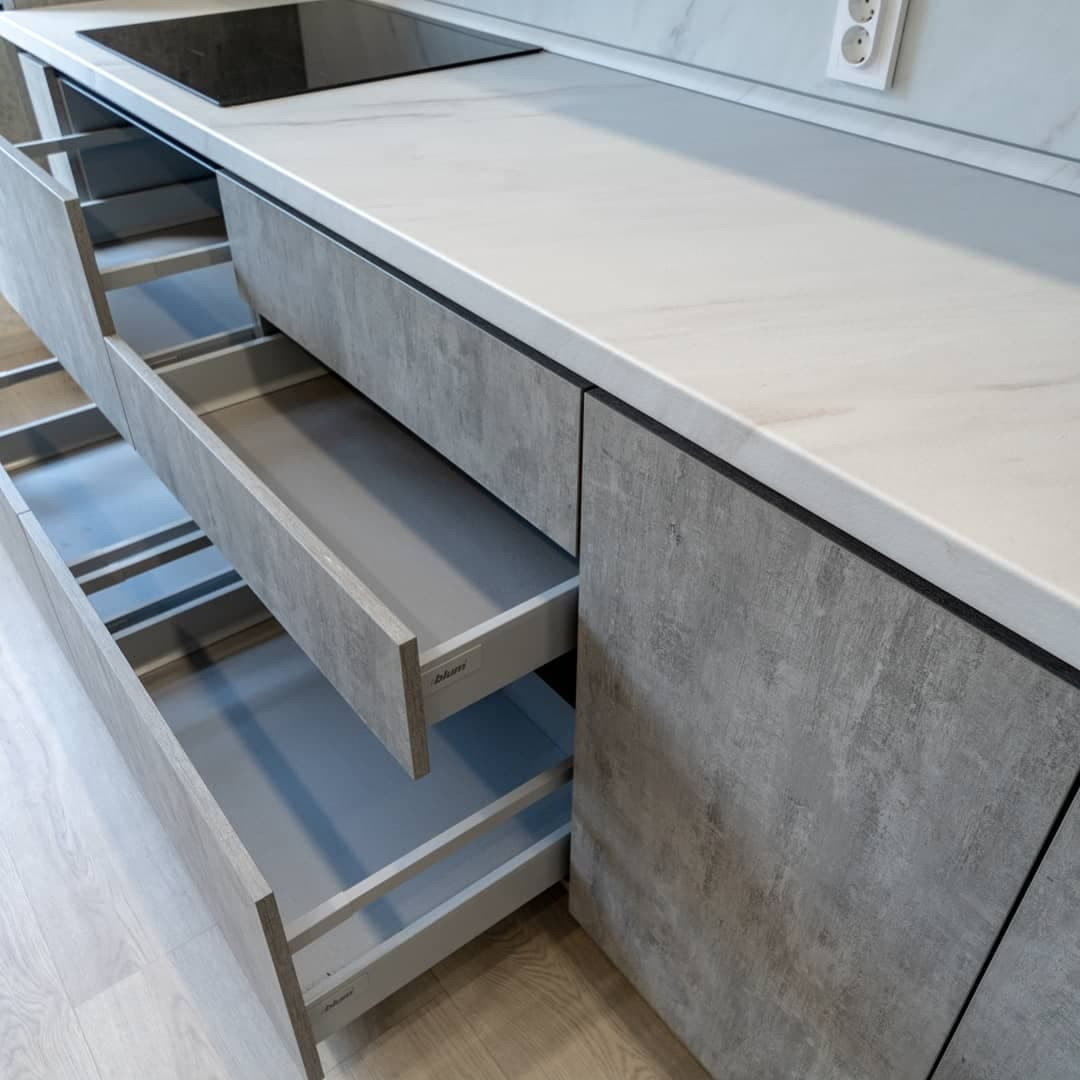 Большая светлая прямая кухня с фасадами под металл и камень