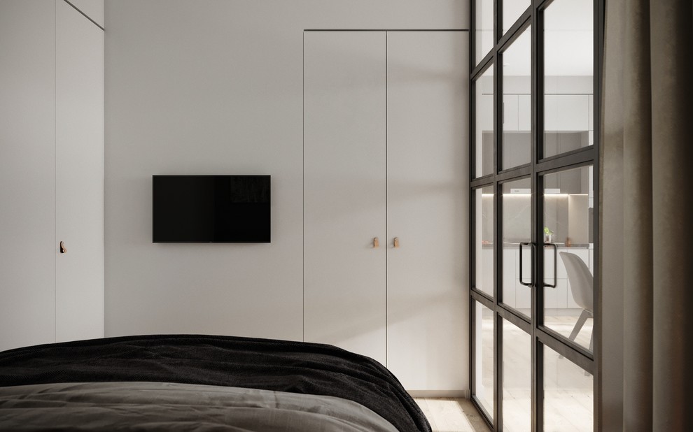 Шкафы для хранения одежды спрятаны в стене, выстроенной S-образно, таким образом