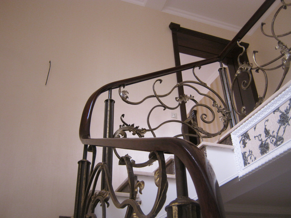 Деревянный гнутый поручень на кованые ограждения лестниц.