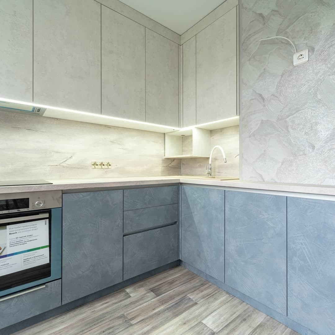 Большая угловая кухня в синем и белом цвете с фасадами под камень