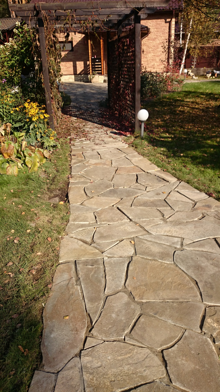 Элемент главной дорожки из натурального камня и деревянная пергола с виноградом