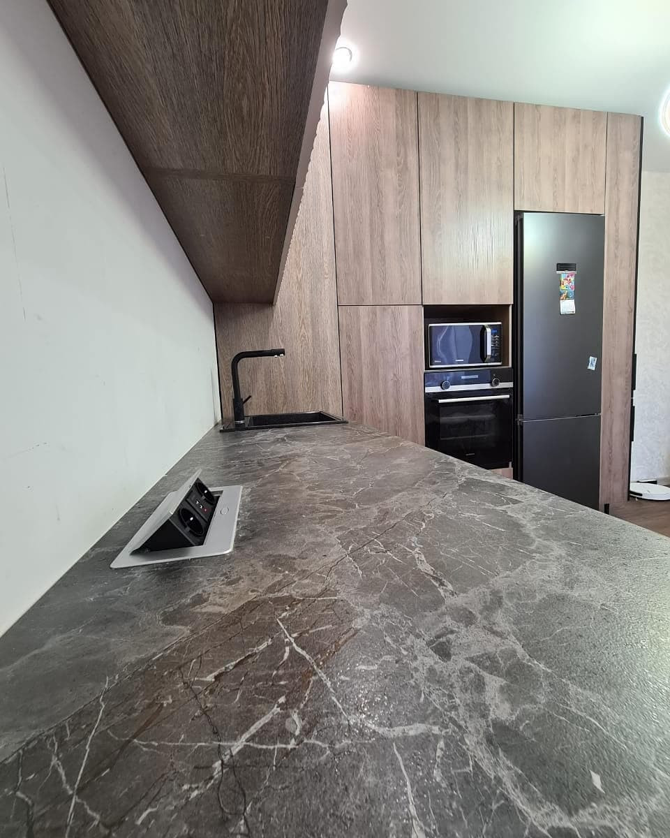 Большая угловая кухня в сером цвете с рифлеными фасадами и витриной