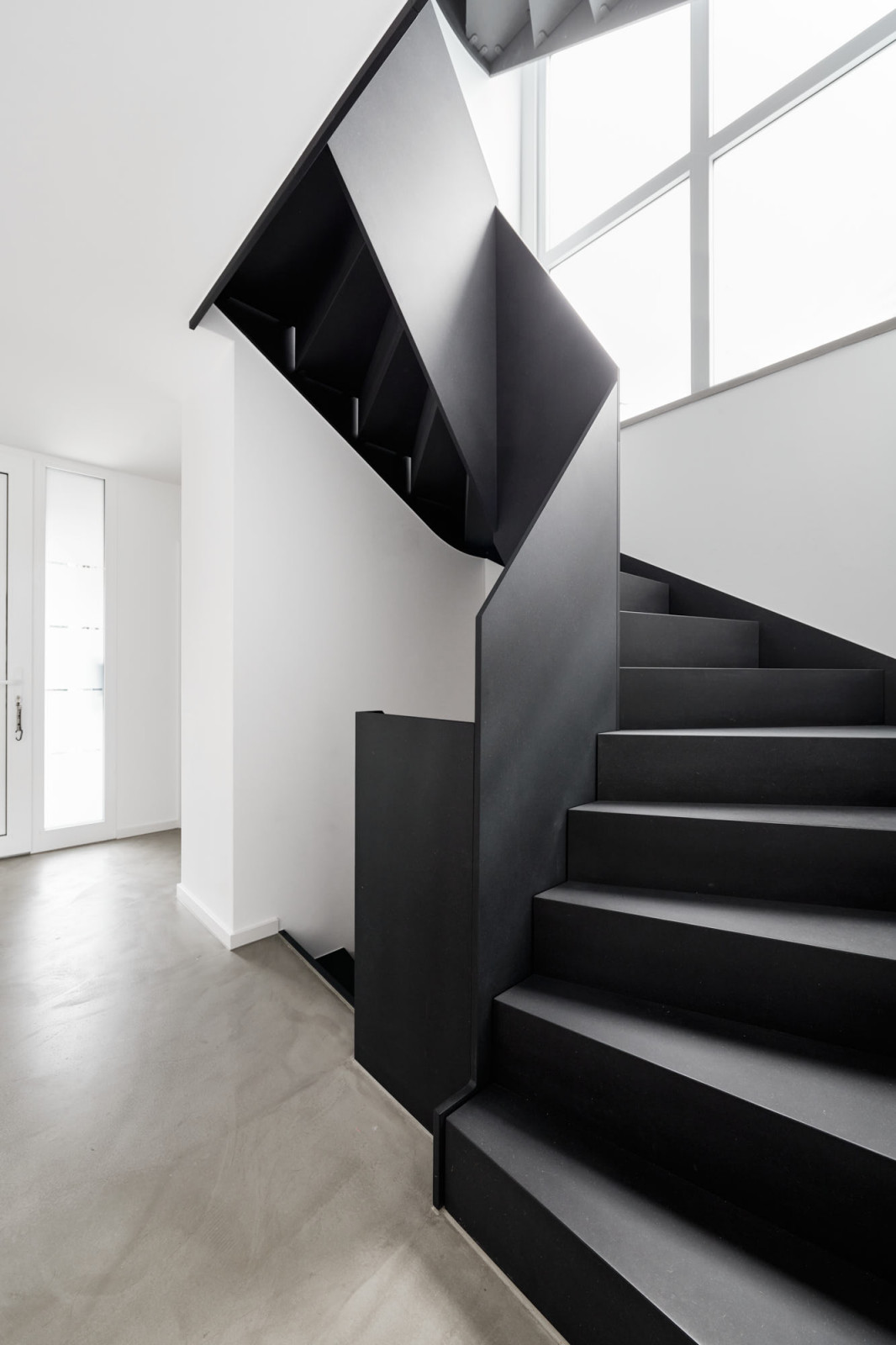 Черная лестница в проеме с окном