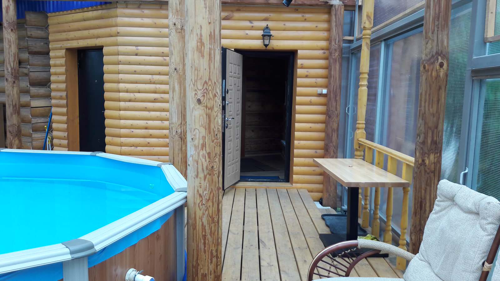 Деревянный дом с фасадом из металического сайдинга, баня с бассейном.