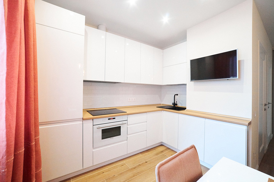 Белая глянцевая кухня с интегрированными ручками