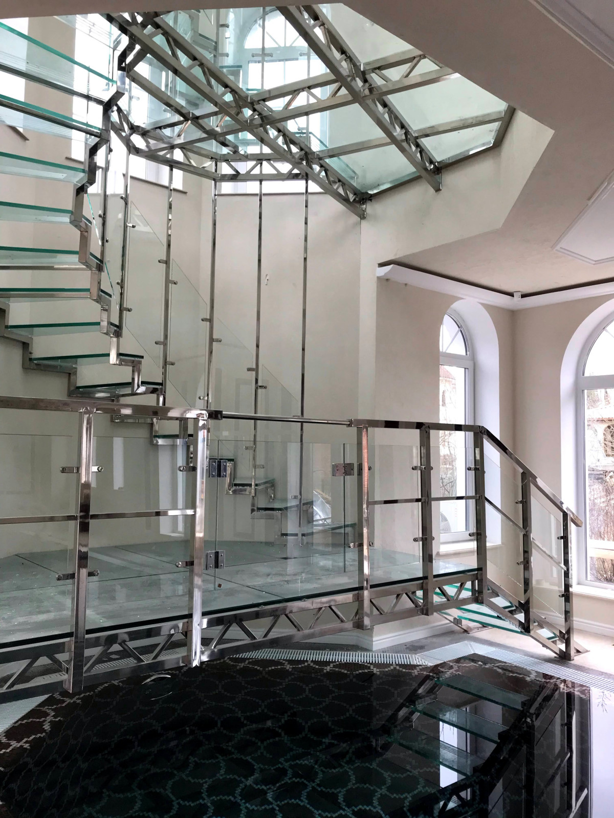 Винтовая стеклянная лестница над бассейном