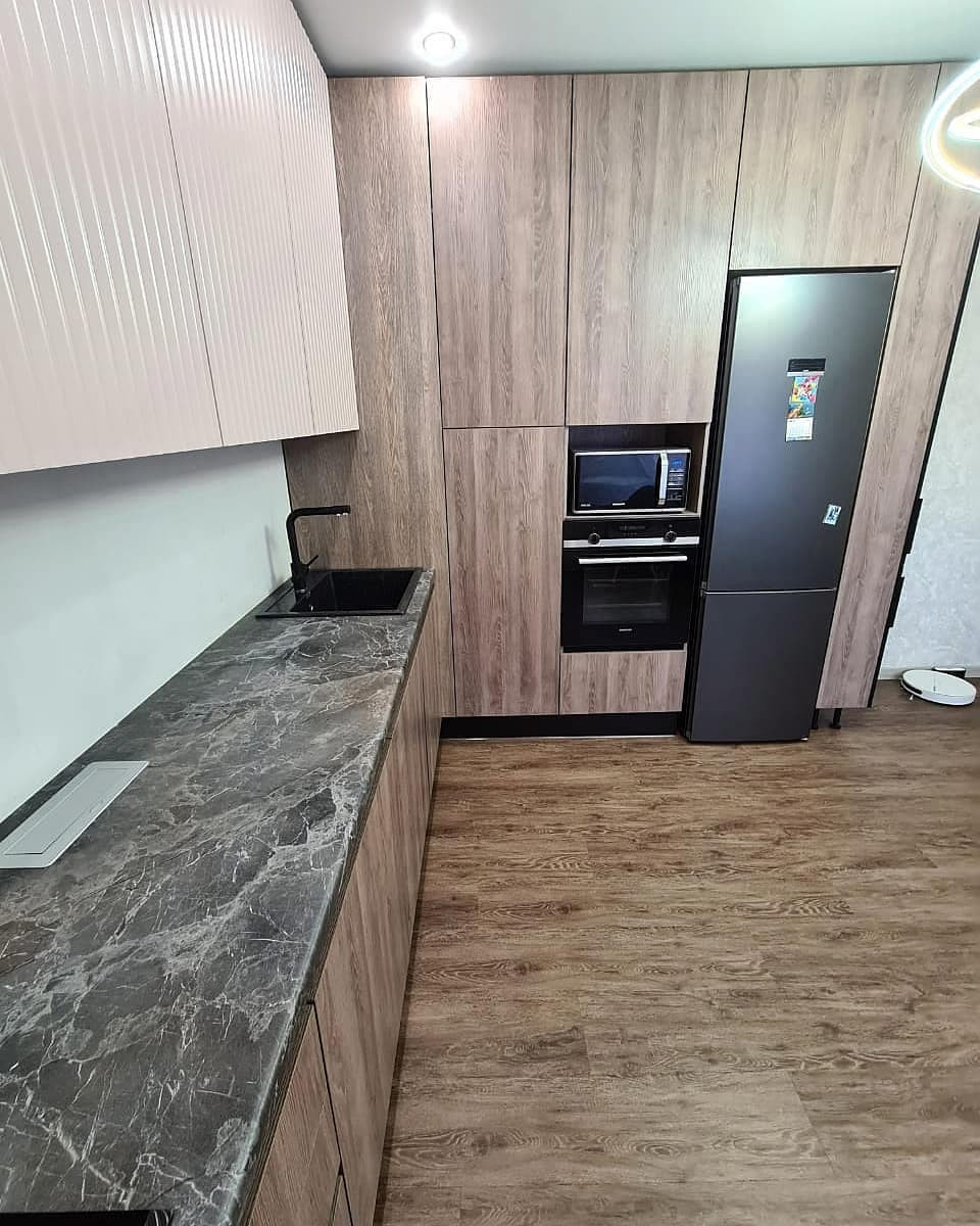 Большая угловая кухня в сером цвете с рифлеными фасадами и витриной