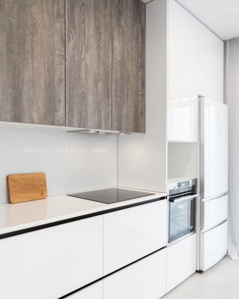 Современная серо-белая кухня в высокими шкафами и барной стойкой