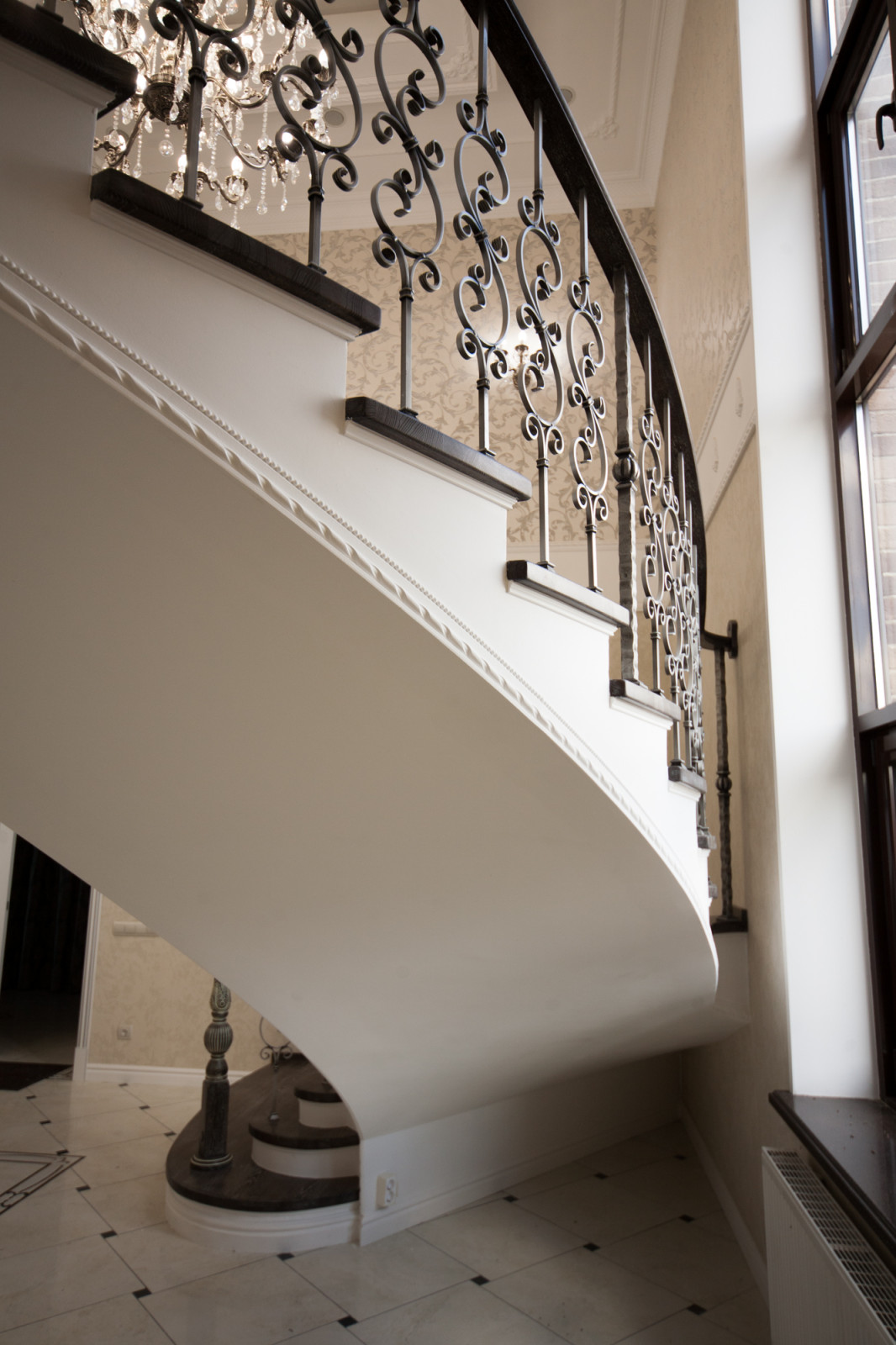 Бетонная лестница со ступенями из дуба и кованными балясинаями