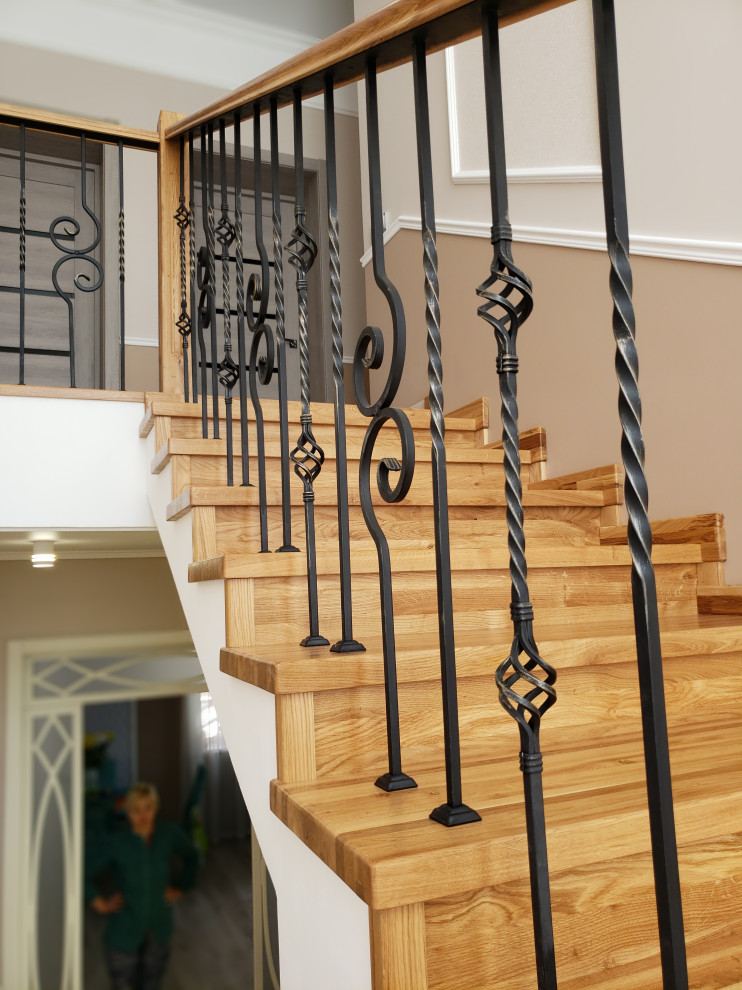 Лестница из дуба с коваными ограждениями