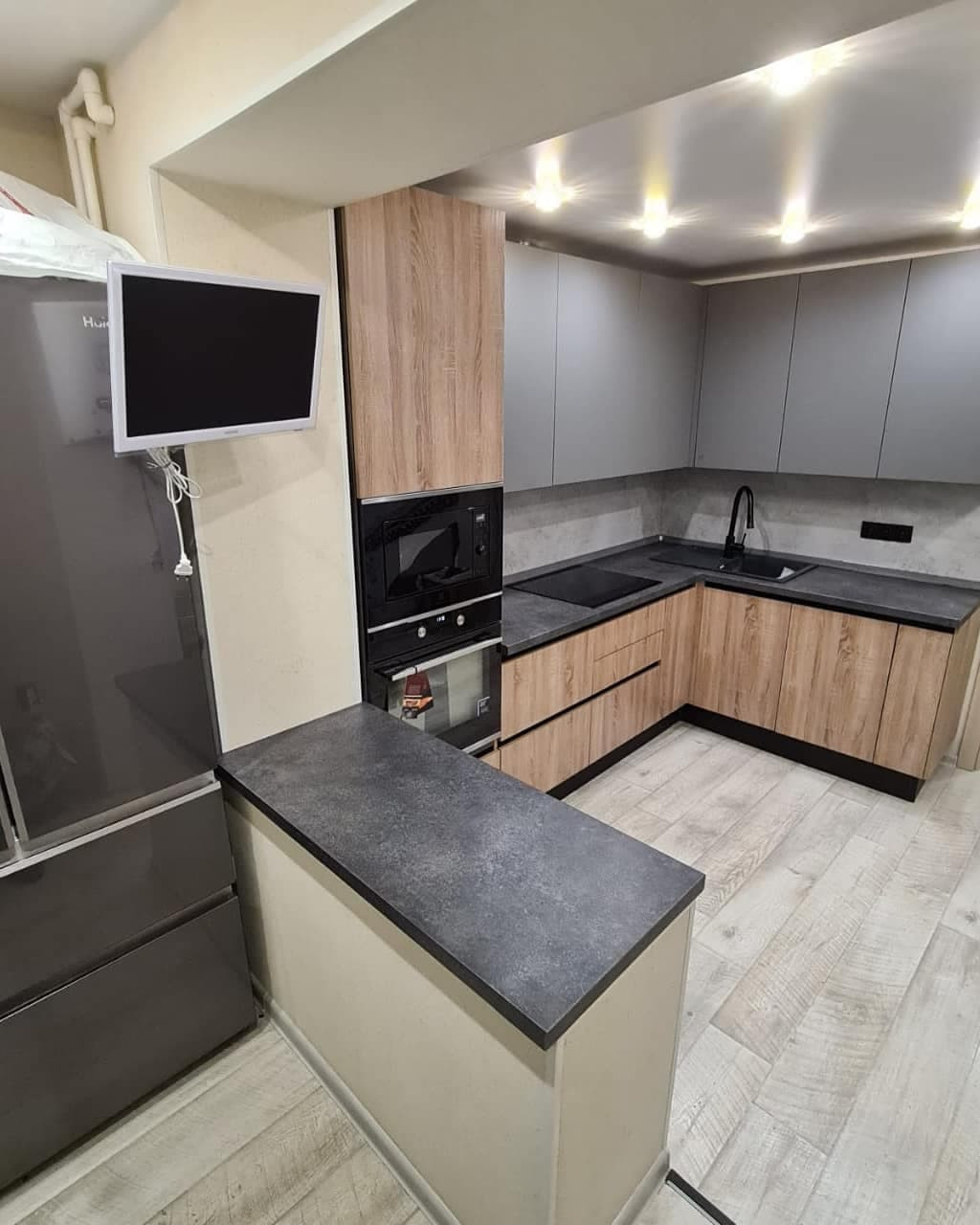 Стильная угловая кухня с деревянными и матовыми фасадами цвета графит