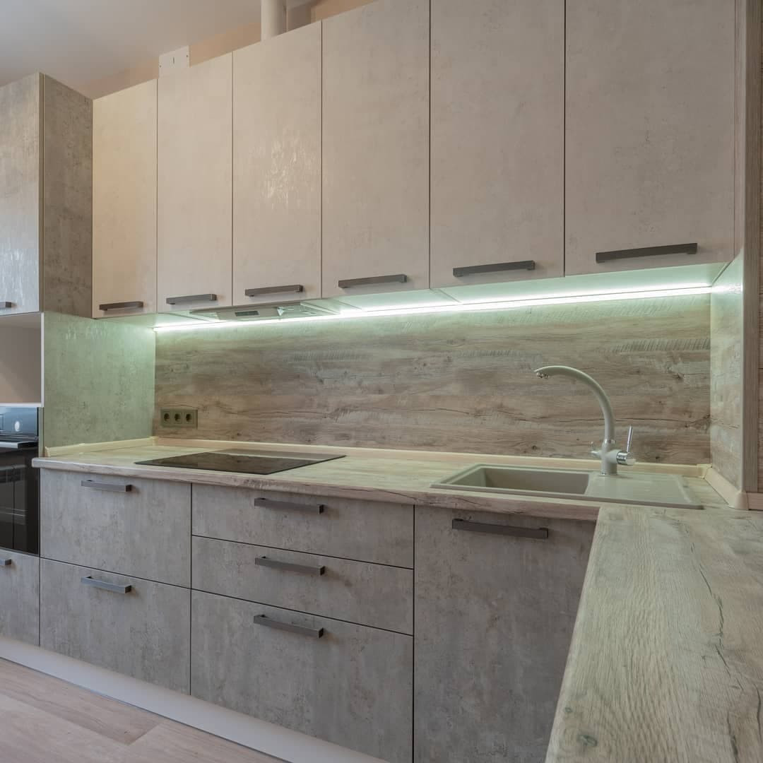 Угловая серо-белая кухня с современными ручками и фасадами под камень