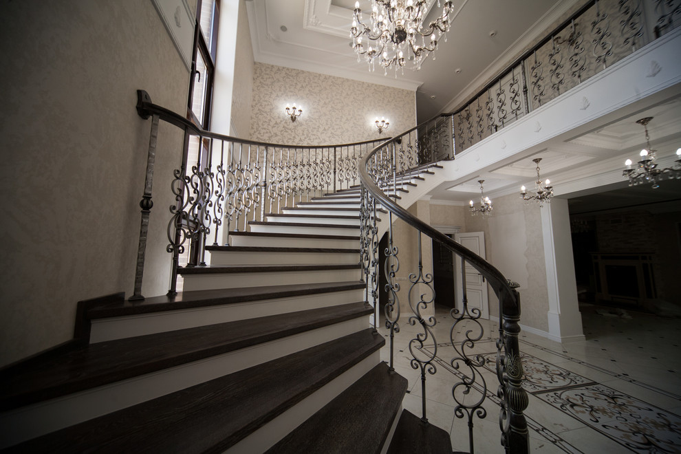 Бетонная лестница со ступенями из дуба и кованными балясинаями