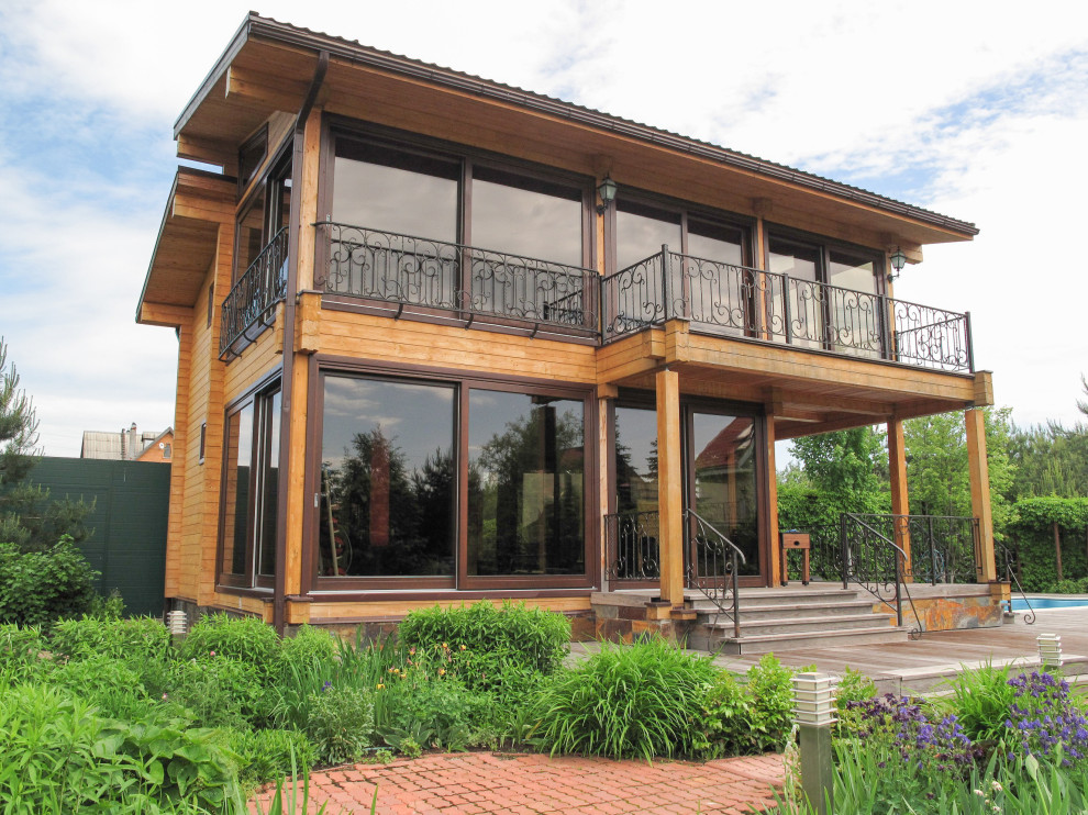 Панорамное остекление загородного дома окнами и порталами из сосны