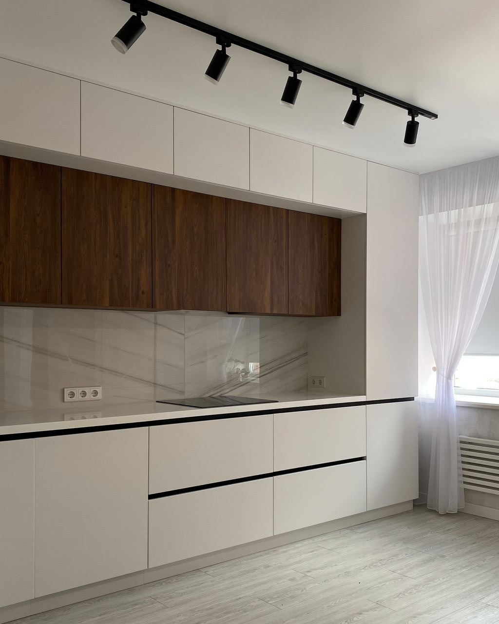 Светлая встроенная угловая кухня с однотонными матовыми фасадами