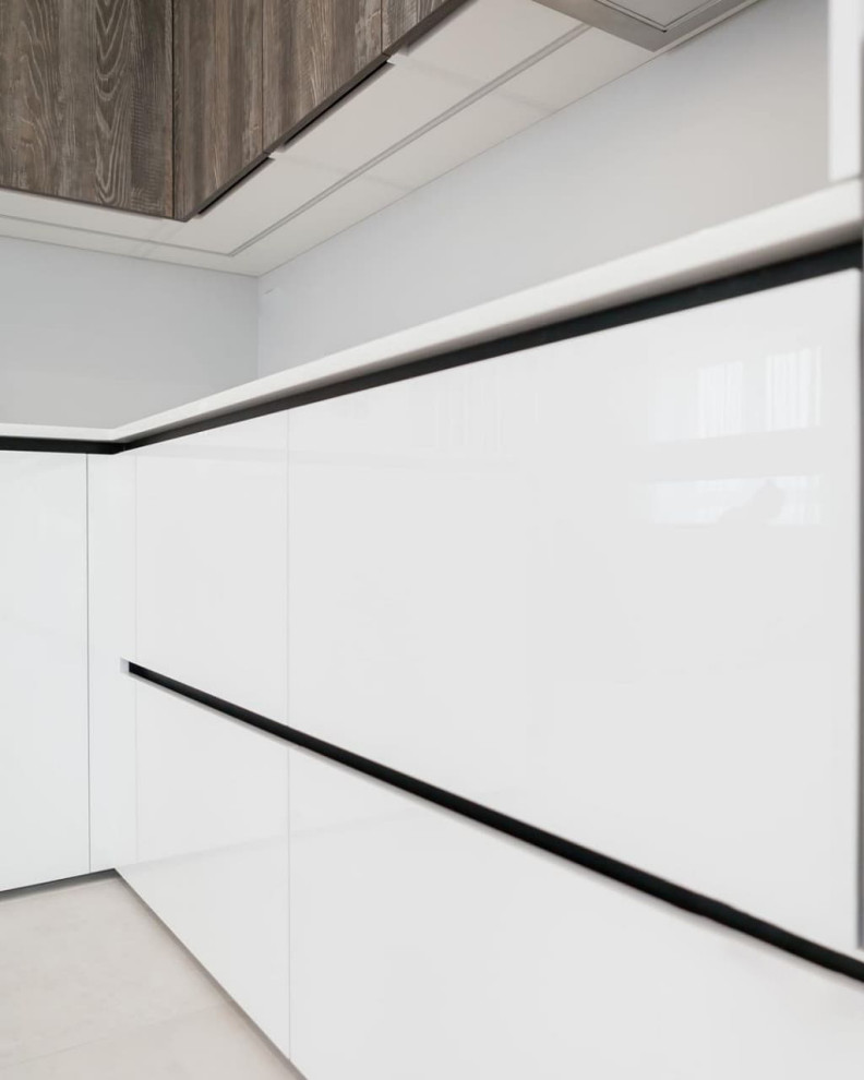 Современная серо-белая кухня в высокими шкафами и барной стойкой