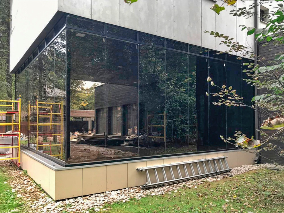 Безрамное остекление веранды и стеклянное ограждение на крыше.