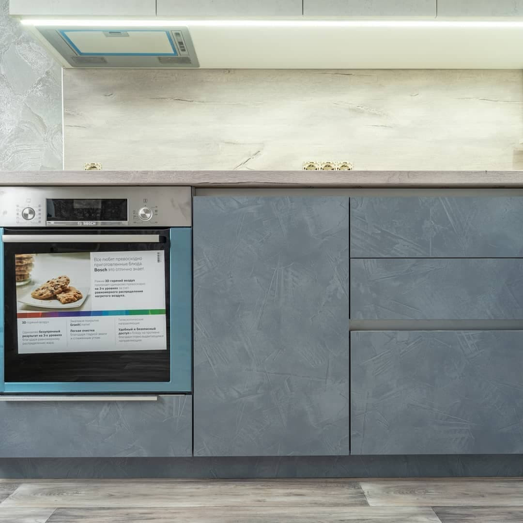 Большая угловая кухня в синем и белом цвете с фасадами под камень