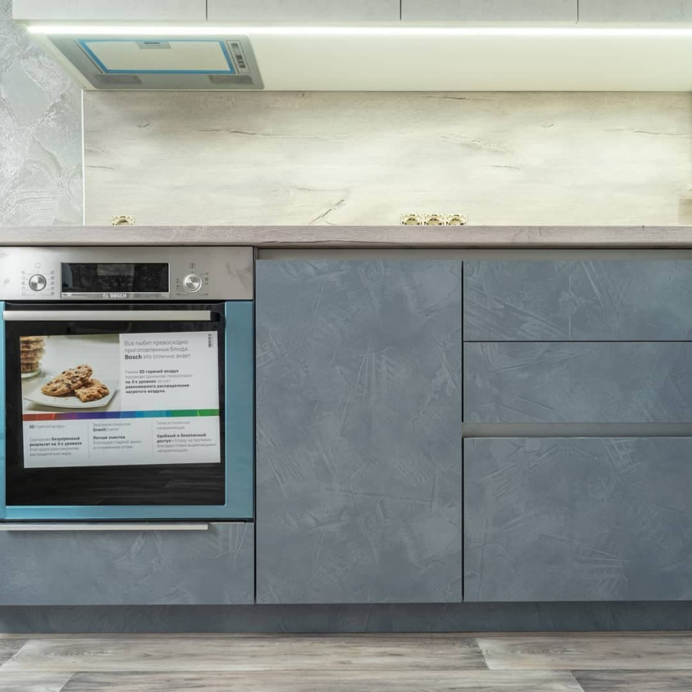 Большая угловая кухня в синем и белом цвете с фасадами под камень