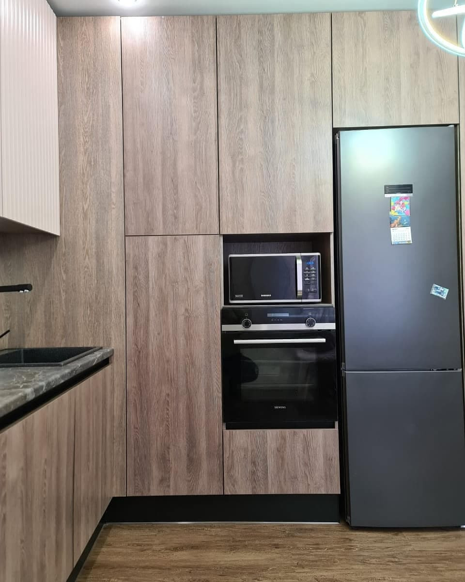 Большая угловая кухня в сером цвете с рифлеными фасадами и витриной