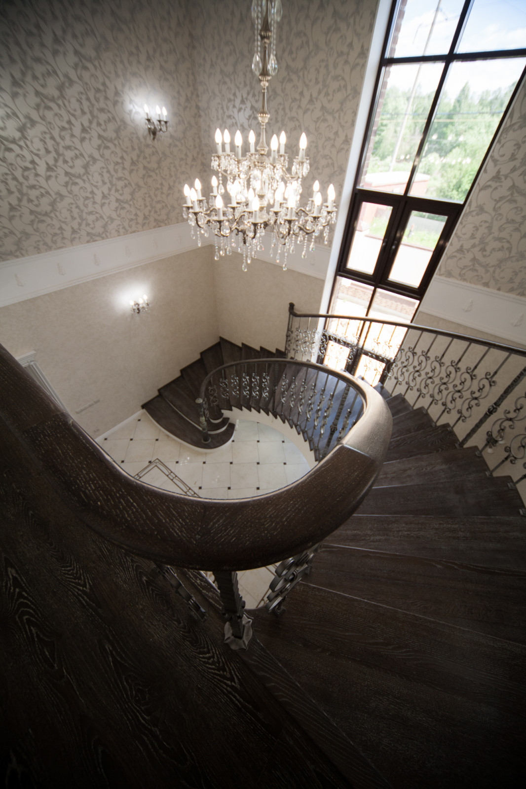 Бетонная лестница со ступенями из дуба и кованными балясинаями