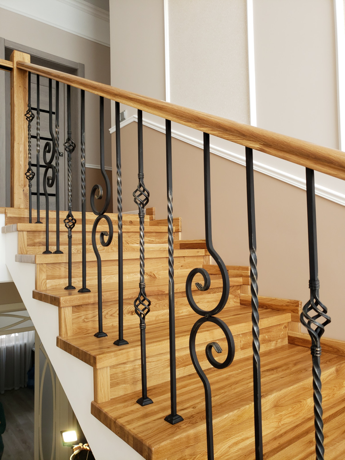 Лестница из дуба с коваными ограждениями