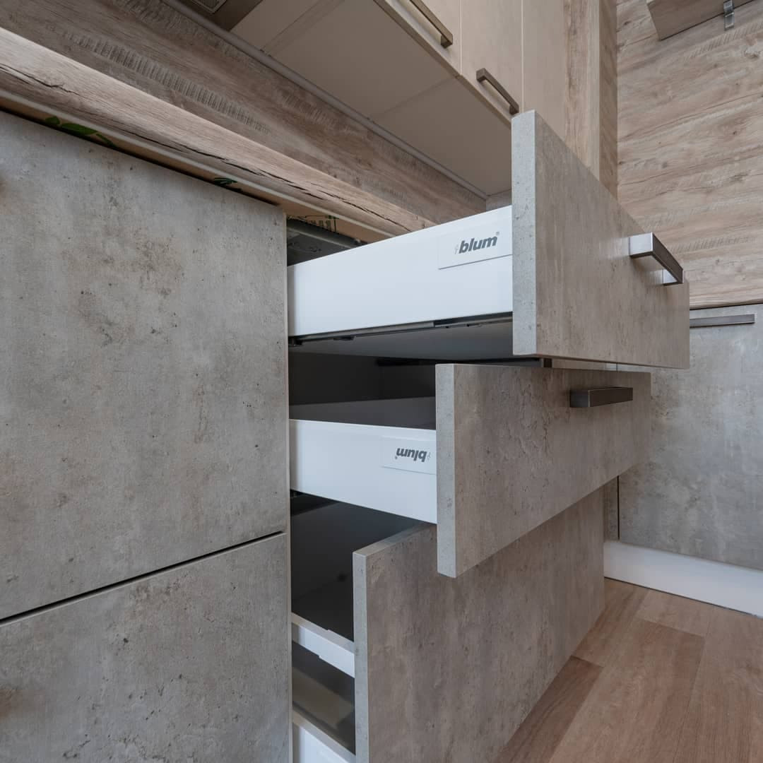 Угловая серо-белая кухня с современными ручками и фасадами под камень