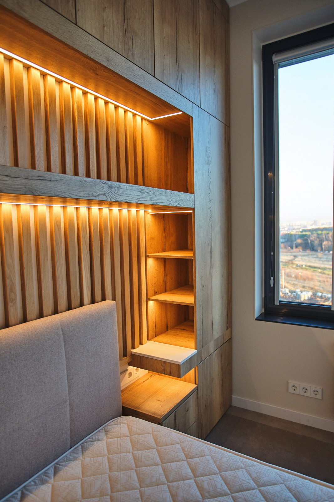 Вместительная система хранения у изголовья кровати с подсветкой