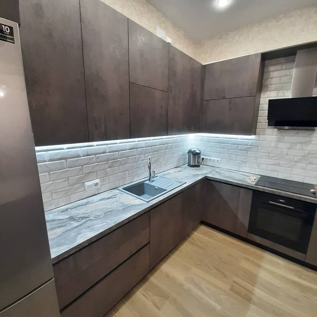 Темная П-образная кухня с полуостровом и фасадами под металл