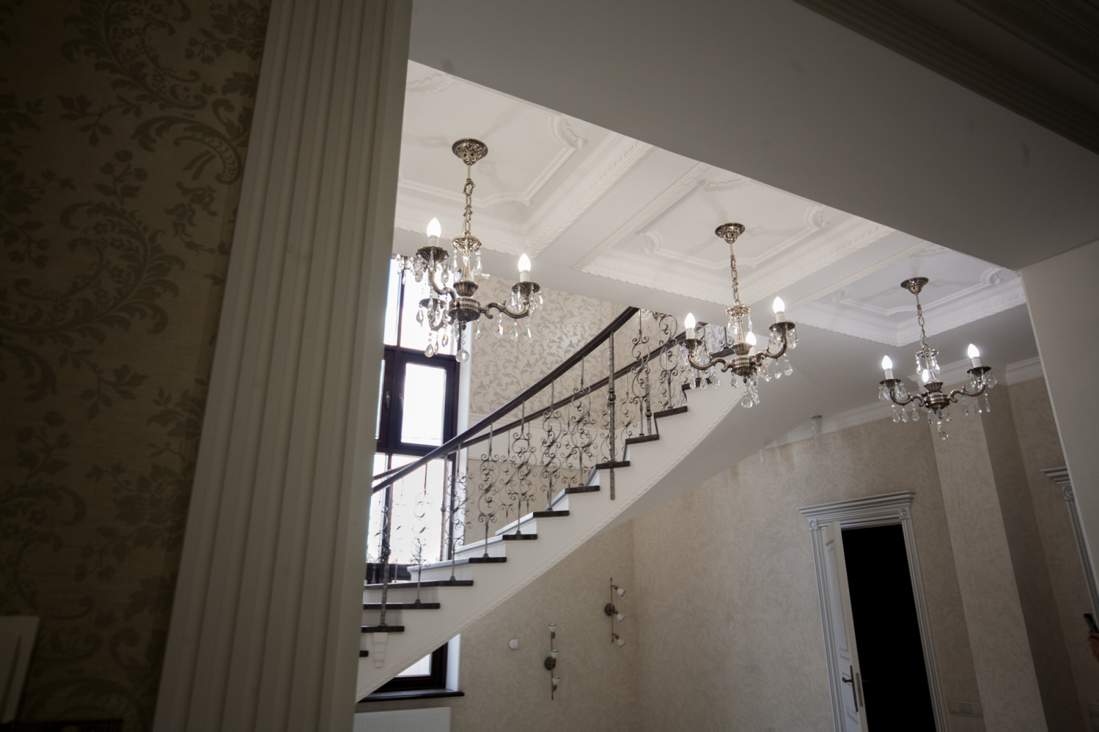 Бетонная лестница со ступенями из дуба и кованными балясинаями