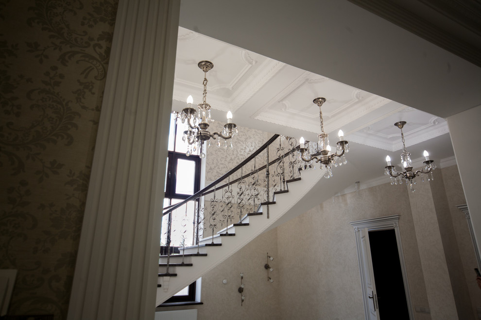 Бетонная лестница со ступенями из дуба и кованными балясинаями