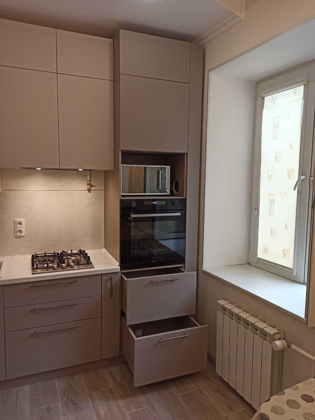 Небольшая кухня в бежевых тонах с комодом