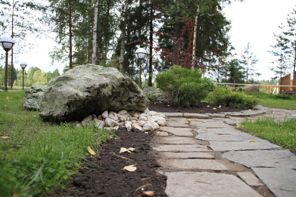 Цветник с камнями и композицией из кустарника