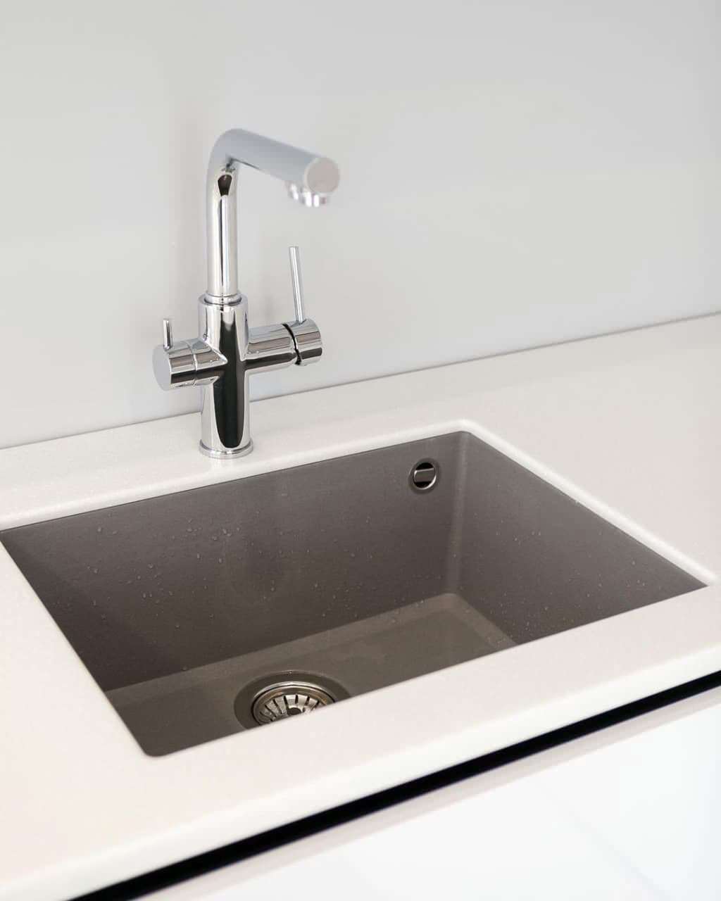 Современная серо-белая кухня в высокими шкафами и барной стойкой