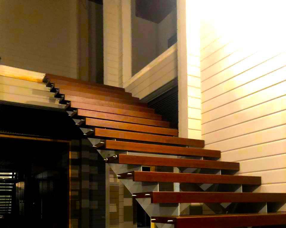 Лестница на металлических тетивах с ограждением из стекла в дом из бруса