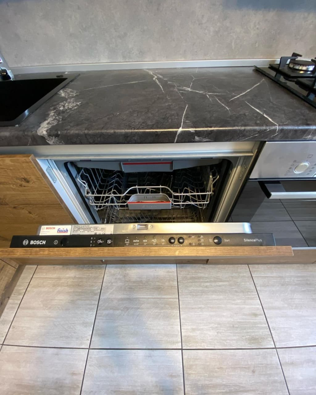 Угловая кухня в коричневом цвете с матовыми и древесными фасадами