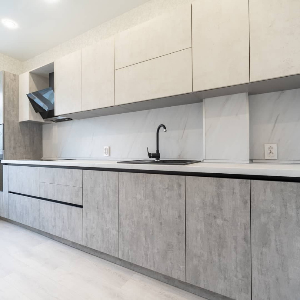 Большая светлая прямая кухня с фасадами под металл и камень