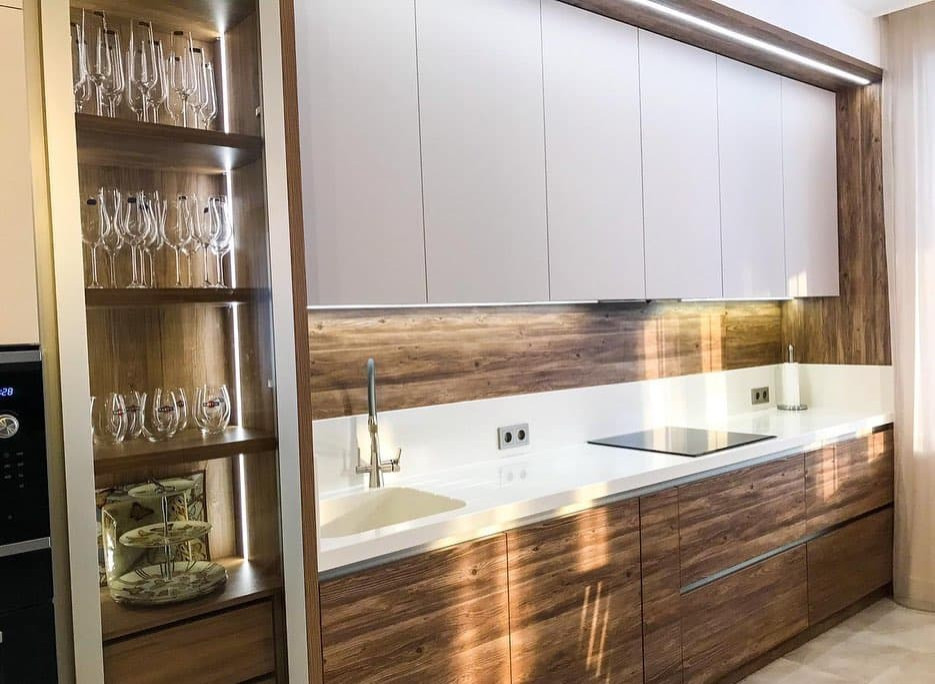 Светлая прямая кухня в стиле неоклассика со стеклянной витриной