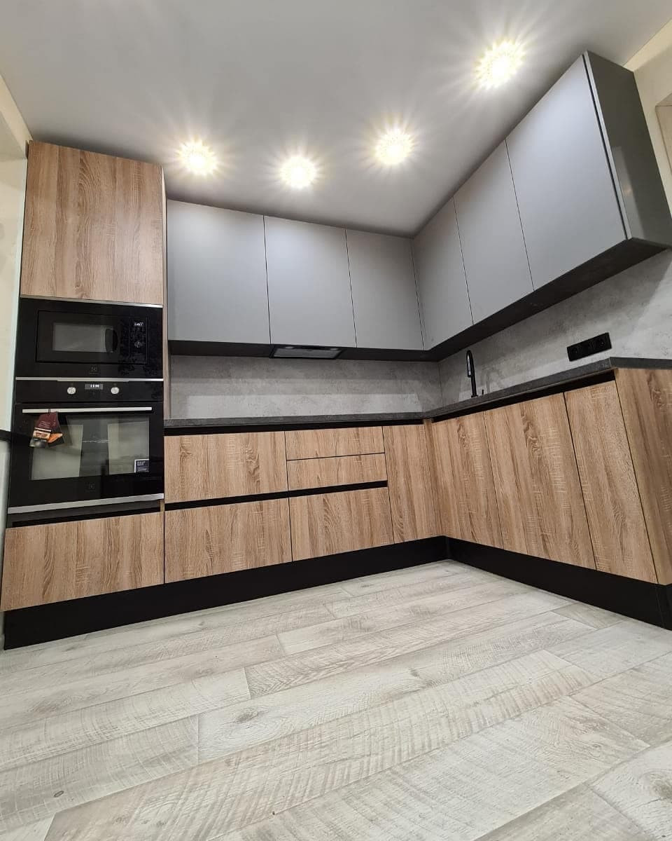 Стильная угловая кухня с деревянными и матовыми фасадами цвета графит