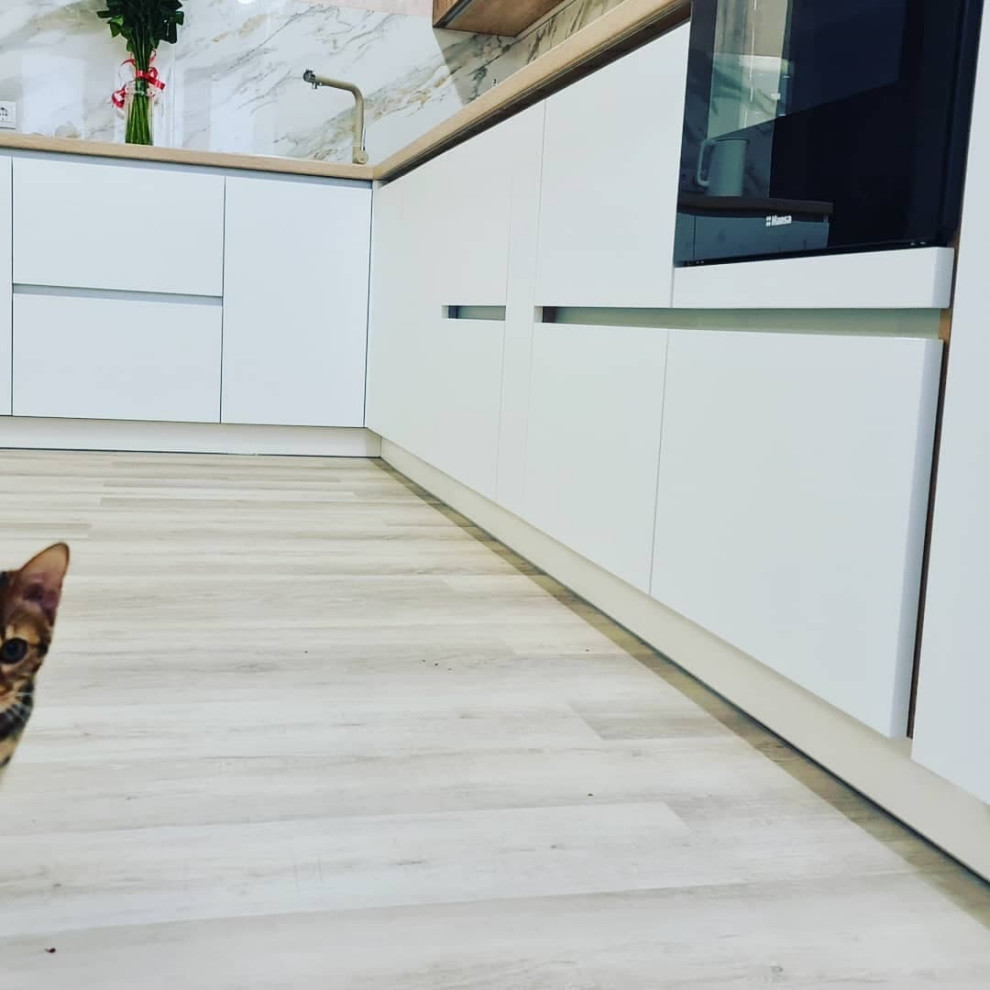 Уютная угловая кухня с фасадами под дерево и серыми матовыми фасадами