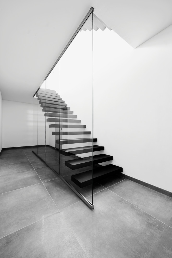 Консольная лестница в черном матовом цвете с ограждением из белого стекла