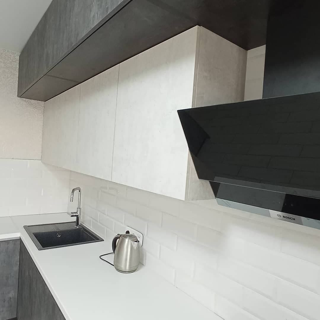 Широкая угловаячерно-белая кухня с фасадами под камень