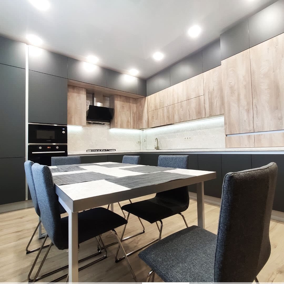 Большая широкая угловая кухня с матовыми и древесными фасадами