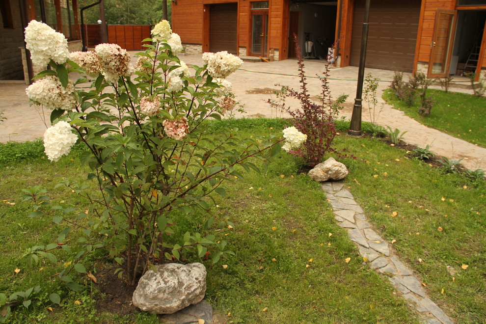 Цветник с камнями и композицией из кустарника